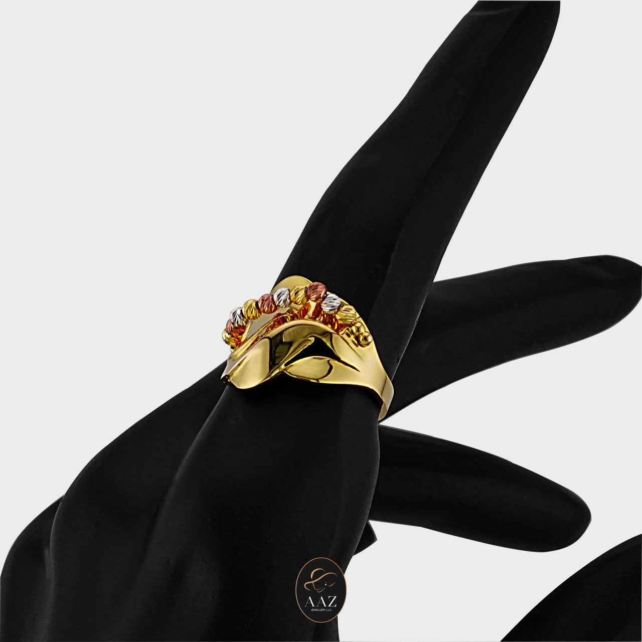 Tri Color Swirl 21K Gold Ring on an index finger