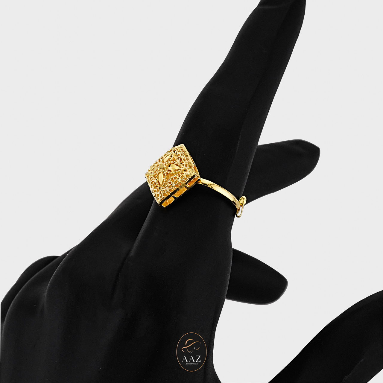 Ornate Square 21K Gold Ring on an index finger with a side angle