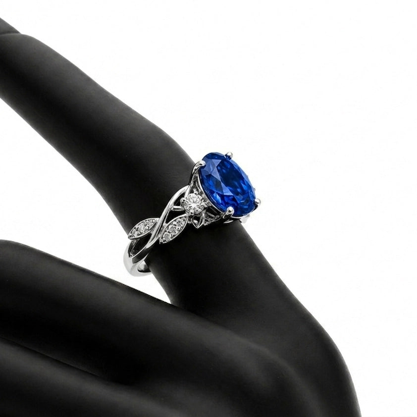 Floral tanzanite ring in 18K white gold on a finger, angled view